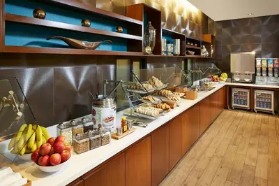 a buffet line in a restaurant with fruit and food at SpringHill Suites by Marriott at Anaheim Resort Area/Convention Center in Anaheim
