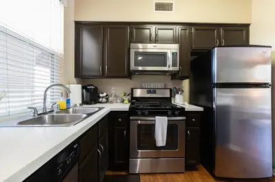 a kitchen with a stainless steel refrigerator and a sink at Modern King Suite Deluxe Living Cali in Santa Clarita