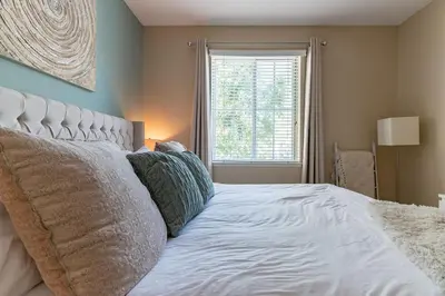 a bedroom with a bed with pillows and a window at Modern King Suite Deluxe Living Cali in Santa Clarita