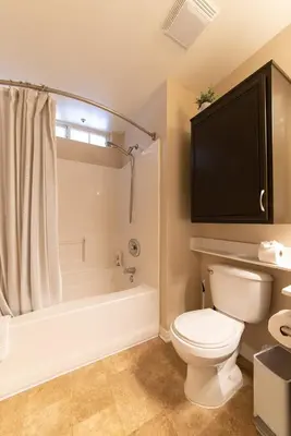 a bathroom with a toilet and a tub and a television at Modern King Suite Deluxe Living Cali in Santa Clarita