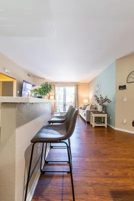 a kitchen with three bar stools in a room at Modern King Suite Deluxe Living Cali in Santa Clarita