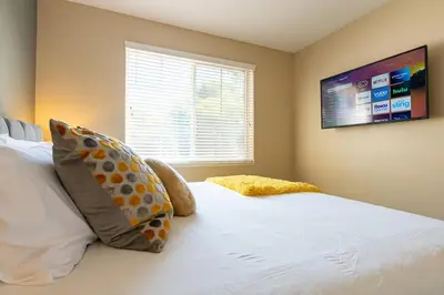 a bedroom with a white bed with pillows and a window at Saints 2BDRM King Suite Deluxe Living Cali in Santa Clarita