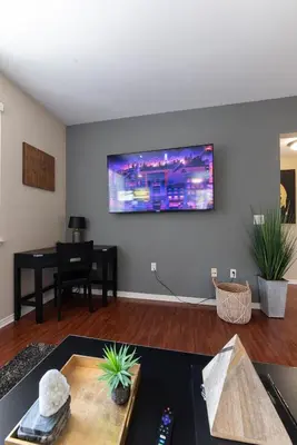a living room with a flat screen tv on the wall at Saints 2BDRM King Suite Deluxe Living Cali in Santa Clarita