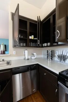 a kitchen with black cabinets and a stainless steel dishwasher at Sky Luxury 2BDRM Suite Deluxe Living Cali in Santa Clarita