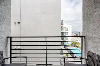 a balcony with chairs and a view of a building at North Hollywood 1br w roof terrace nr bars LAX-1130 in Los Angeles
