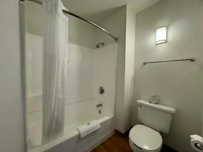 a white bathroom with a toilet and a shower at Studio 6 Bellflower CA Los Angeles in Bellflower