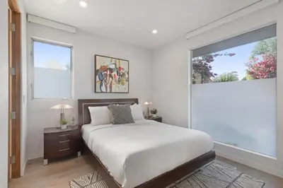 a bedroom with a bed and a large window at Lindenhurst in Los Angeles