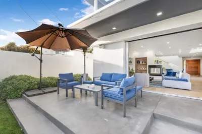a patio with blue chairs and an umbrella at Lindenhurst in Los Angeles
