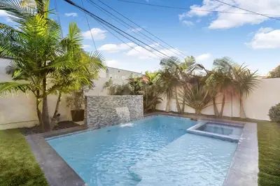 a swimming pool in a yard with palm trees at Lindenhurst in Los Angeles