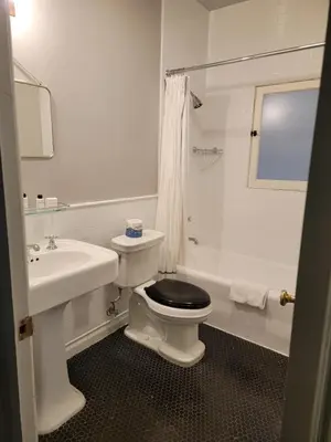a white bathroom with a toilet and a sink at Cozy Studio With Franklin Village View - 30 Day Minimum Stay in Los Angeles