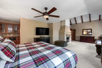 a bedroom with a king sized bed and a fireplace at Mountain Memories on Tavern Bay in Lake Arrowhead