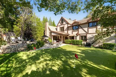 a house with a green yard with a putting green at Mountain Memories on Tavern Bay in Lake Arrowhead