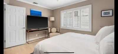 a bedroom with a bed and a flat screen tv at Chic Venice Beach Bungalow Steps from the Canals & Beach in Los Angeles