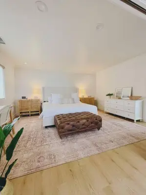 a large white bedroom with a bed and a rug at Summer Lillie #3 in Summerland