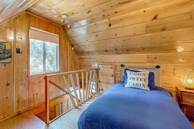 a bedroom with a bed in a log cabin at El Sueńo in Crestline