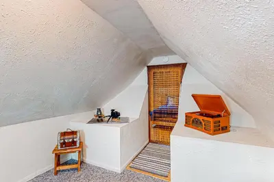 an attic room with a staircase and a wooden door at El Sueńo in Crestline