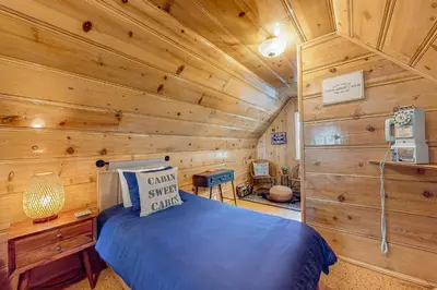 a bedroom with a bed in a wooden cabin at El Sueńo in Crestline