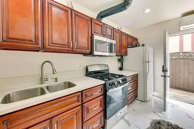 a kitchen with wooden cabinets and a sink and a stove at Anaheim Hills Retreat - 17 Mi to Disneyland! in Anaheim