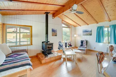 a living room with a couch and a stove at Scenic Kernville Getaway with Deck and Mountain Views! in Kernville
