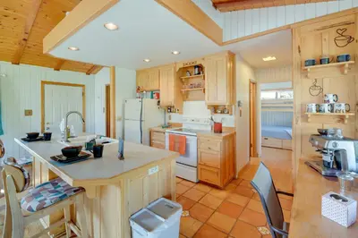 a kitchen with wooden cabinets and a counter top at Scenic Kernville Getaway with Deck and Mountain Views! in Kernville