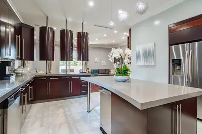a large kitchen with brown cabinets and a large island at Regal 4 bed with hot tub close to Universal sleeps 15 in Los Angeles
