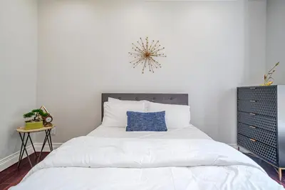 a bedroom with a white bed with a blue pillow at Regal 4 bed with hot tub close to Universal sleeps 15 in Los Angeles