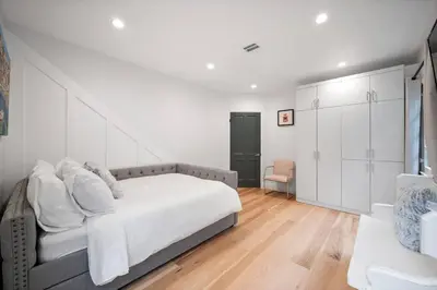 a white bedroom with a bed and a chair at Chic 3BR Oasis in Studio City:Toluca Lake Adjacent in Los Angeles
