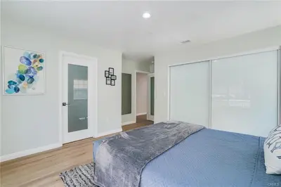 a white bedroom with a bed with a blue blanket at Salt Water Pool Over Look Rocky Mountain View in Sierra Madre