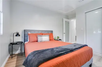 a bedroom with a large bed with an orange blanket at Salt Water Pool Over Look Rocky Mountain View in Sierra Madre