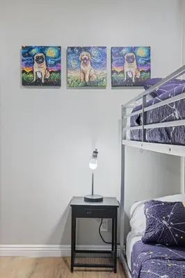 a bedroom with a bunk bed and a table with a night stand at 5 Mins Walk To Oldtown Monrovia Cozy 4 Br Home in Monrovia