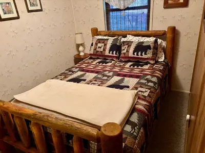 a wooden bed with a quilt on it in a bedroom at Sequoia National Forest CabinD in Panorama Heights