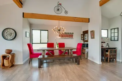 a dining room with a wooden table and red chairs at Malibu Retreat with Balcony and Mountain Views in Malibu