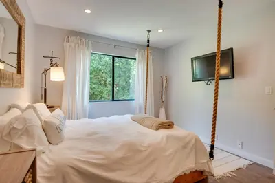 a bedroom with a large white bed in a room with a window at Malibu Retreat with Balcony and Mountain Views in Malibu