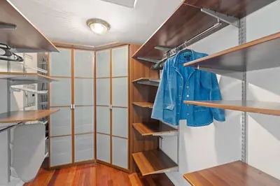 a walk in closet with wooden shelves and a blue jacket at Central Location Family Size Home in Temple City