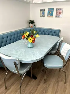 a table with chairs and a vase with flowers on it at Disneyland close FAMILY home! in Fullerton