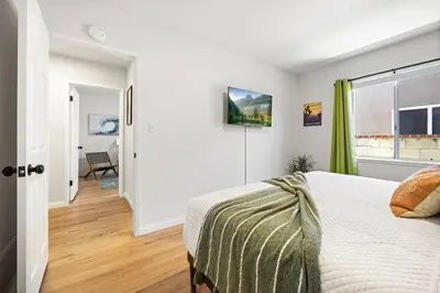 a white bedroom with a bed and a window at Disneyland close FAMILY home! in Fullerton