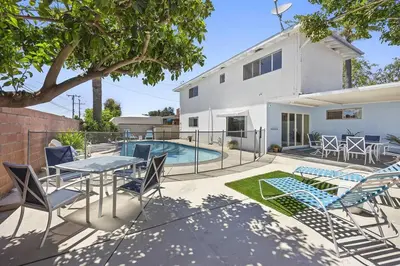 a patio with a table and chairs and a swimming pool at Disneyland close FAMILY home! in Fullerton
