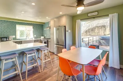 a kitchen with a wooden table and chairs and a table at Running Springs Cabin with Spacious Deck and Hot Tub! in Running Springs
