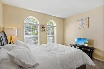 a bedroom with a white bed and two windows at Luxury 2BR/2BA! 5 MIN to Disney! in Anaheim