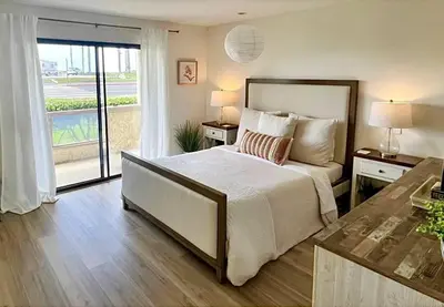 a bedroom with a large bed and a balcony at Beachfront Paradise in Port Hueneme