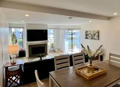 a living room with a couch and a dining room table at Beachfront Paradise in Port Hueneme