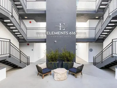 a lobby with three chairs and a pillar with a sign at Redondo Beach 1BR w Pool Gym 1 block from beach LAX-438 in Redondo Beach