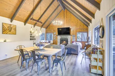 a dining room and living room with a table and chairs at Cozy and Chic Lake Arrowhead Cabin with Deck! in Lake Arrowhead