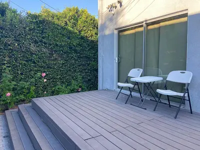 two chairs and a table on a wooden deck at Hollywood Guesthouse in Los Angeles