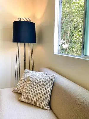 a lamp sitting next to a couch with a window at Hollywood Guesthouse in Los Angeles