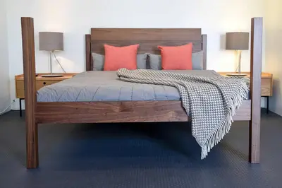 a bedroom with a wooden bed with pink pillows at Hollywood Guesthouse in Los Angeles
