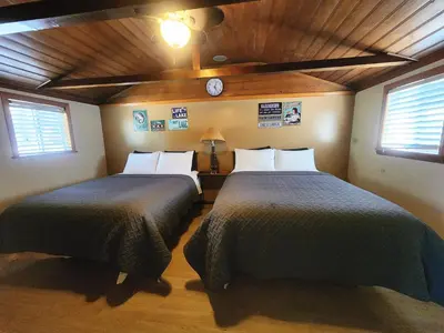two beds in a room with two windows at Creek Runner's Lodge in Big Bear Lake