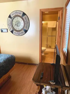 a living room with a clock on the wall and a table at Creek Runner's Lodge in Big Bear Lake