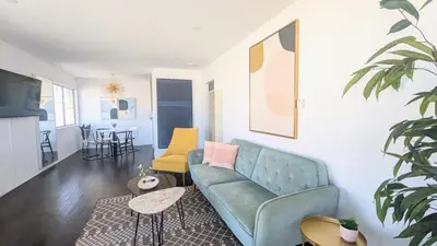 a living room with a blue couch and yellow chairs at Ocean View 1 Bedroom Manhattan Beach in Manhattan Beach