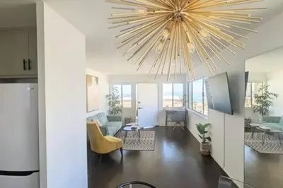 a living room with a large chandelier hanging from the ceiling at Ocean View 1 Bedroom Manhattan Beach in Manhattan Beach